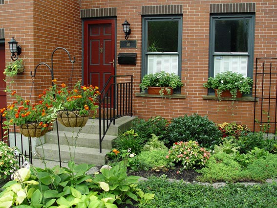Window boxes, flower pots and widened foundation gardens add colorful curb appeal to this small Buffalo, NY, city garden.